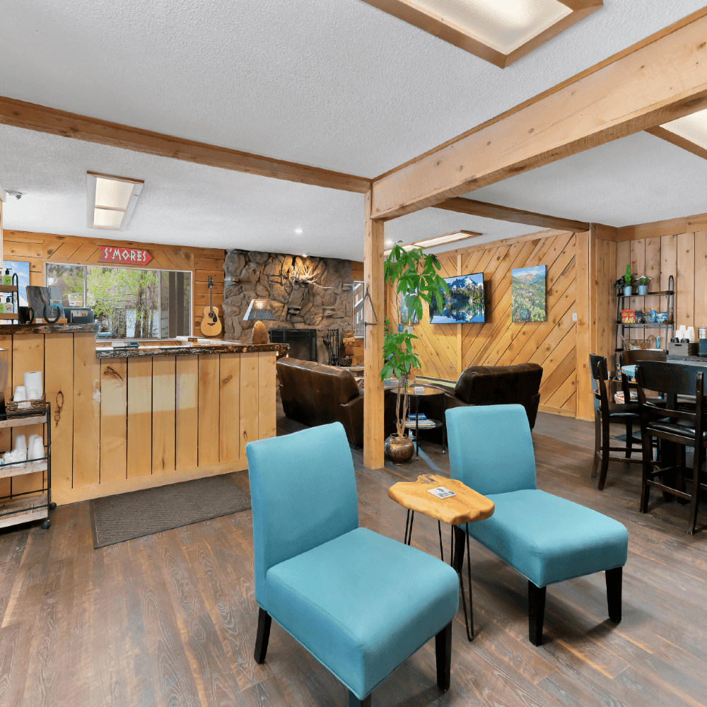 Cozy lounge area with blue chairs, wooden accents, and a welcoming reception desk.